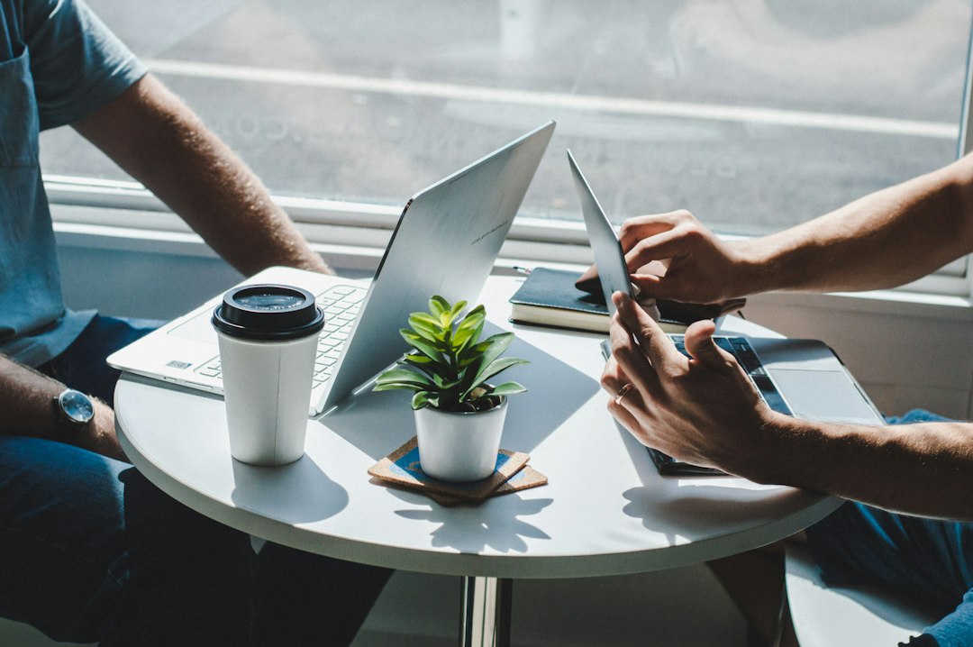 Two people meeting over coffee with a laptop and a tablet